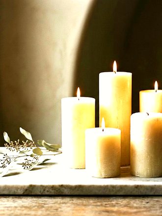 Pillar candles burning on a marble tray.