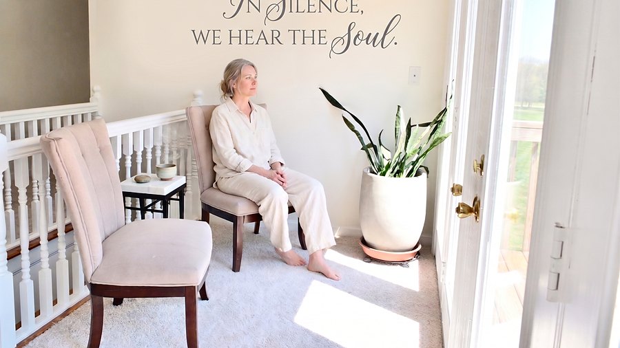 A guest sitting quietly in the corner by the deck doors, under the words In Silence, We Hear The Soul.