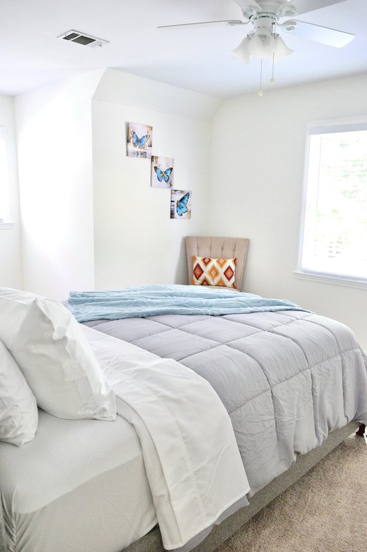 Amara Verde, the room with its ceiling fan, window and framed butterfly prints.