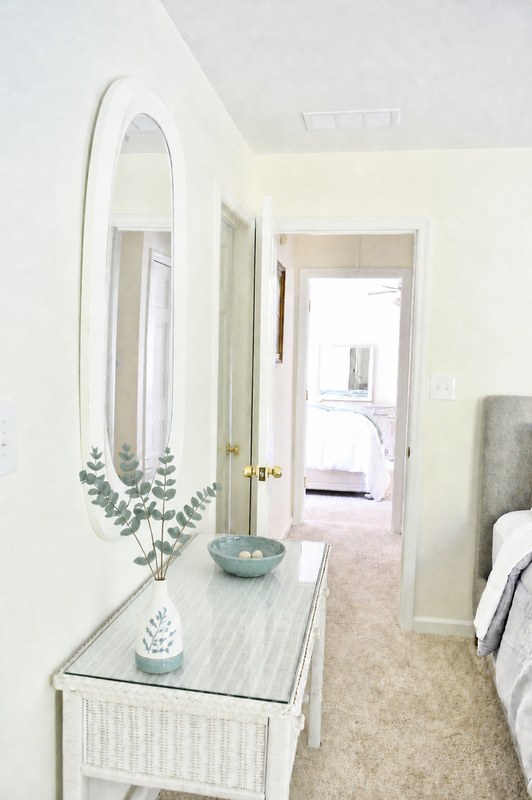Amara Verde, the white console table and oval mirror, looking through the doorway to the bed.