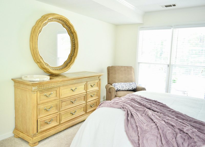 Élan Royale, the wooden dresser and gilt mirror with the bed beside it.