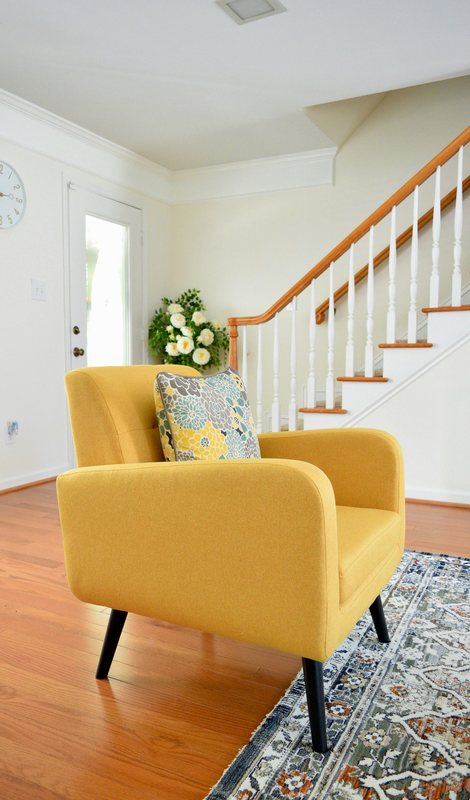 A yellow armchair beside the staircase in the entrance hall.