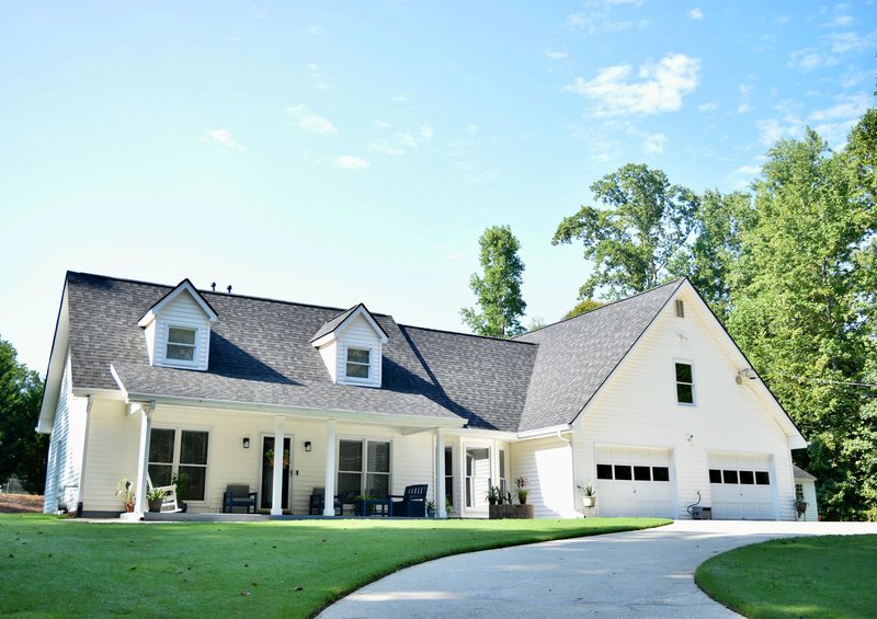 The house seen across the front lawn, with the porch and the garage wing.