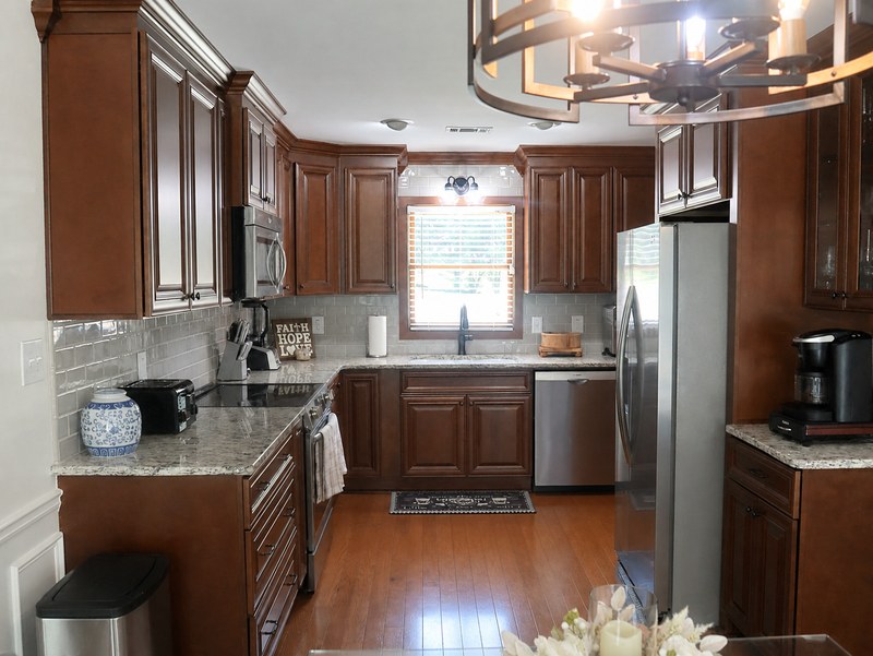 The kitchen, cherry cabinets and granite worktops around a window over the sink.