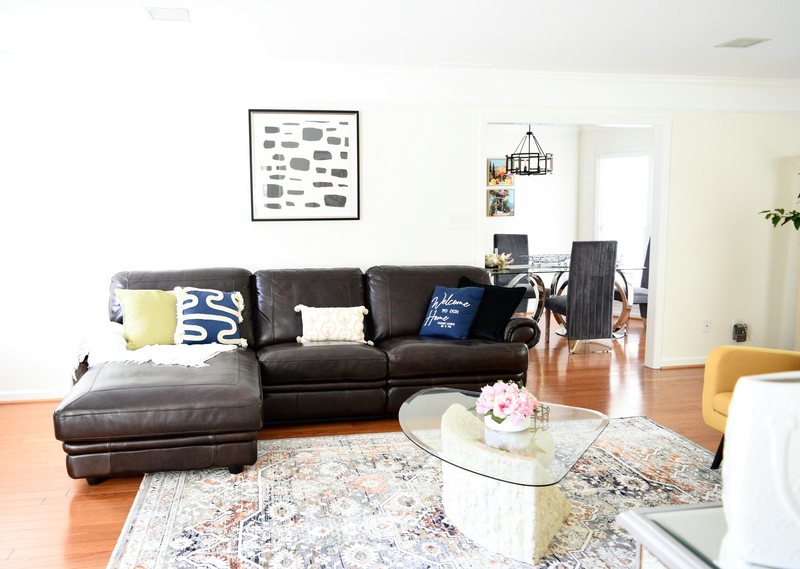 The leather sectional with its cushions, looking through to the dining room.