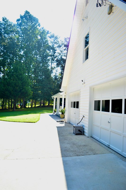 The driveway running down the side of the house past the garage doors.