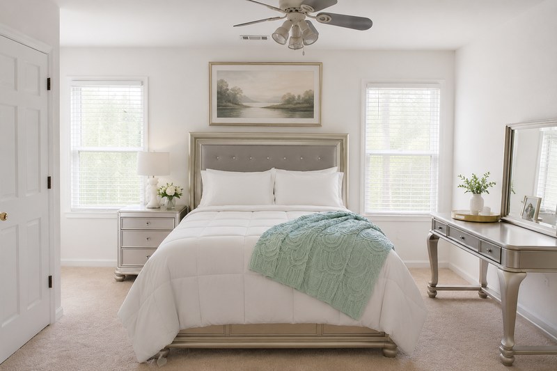 Soléa Serenity, the bed with a green throw between two windows, with the vanity table.